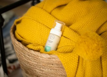 white and green plastic bottle on yellow textile